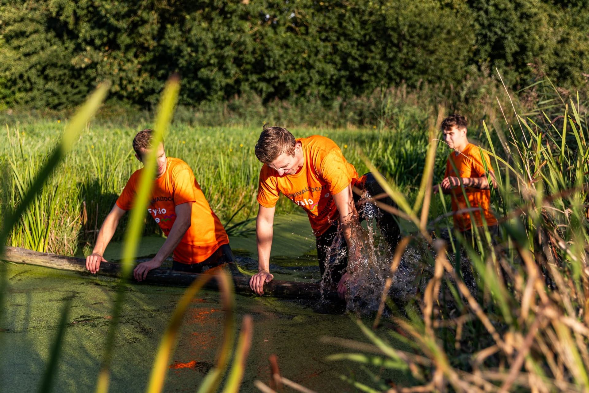 Deelnemers door de modder tijdens de survivalrun