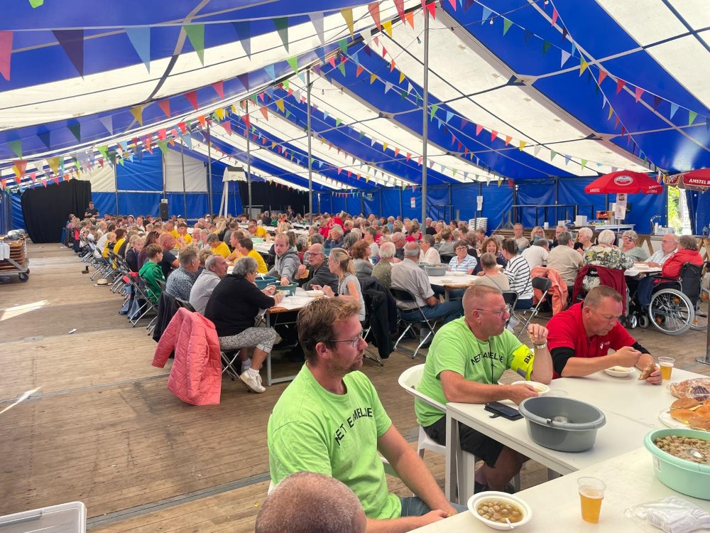 Lange tafels in de feesttent tijdens de dorpsmaaltijd